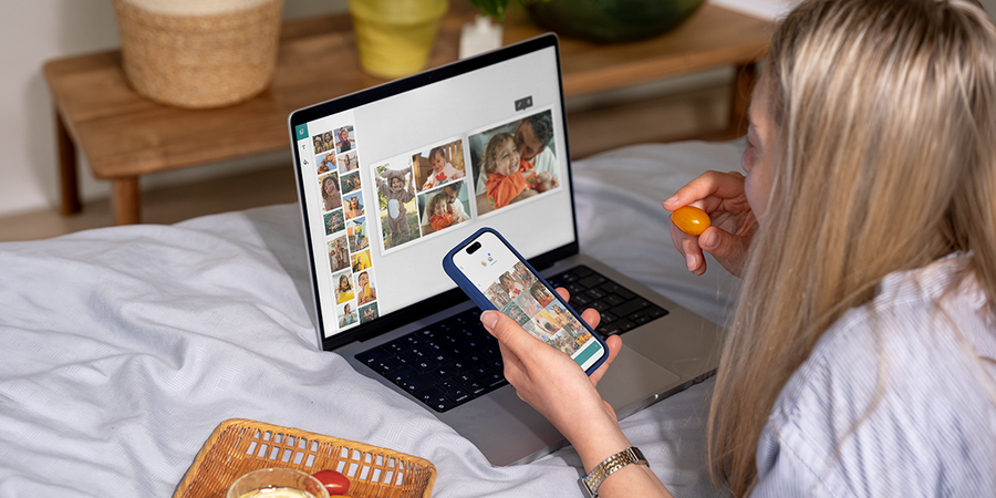 A woman using the Photobox Desktop App on her laptop while eating a cherry tomato to create a personalised photo book, inspiring the best photo book maker and creative photo book software.