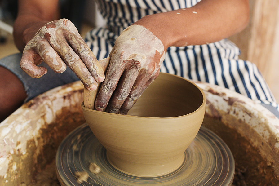 A woman making pottery during a craft workshop, a creative hen party idea for a memorable hen do with Photobox.