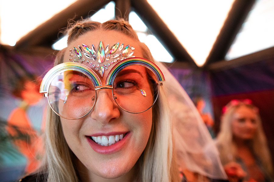 A woman wearing novelty sunglasses and face jewels as costume ideas for a hen party, providing inspiration for a fun hen do with Photobox.