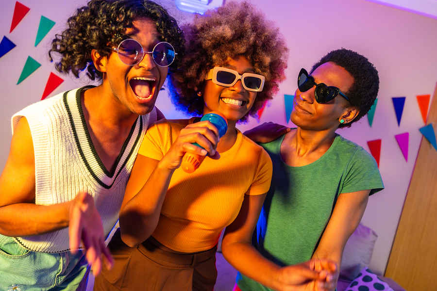 Three people singing karaoke at a hen party, a fun and classic activity for an unforgettable hen do with Photobox.