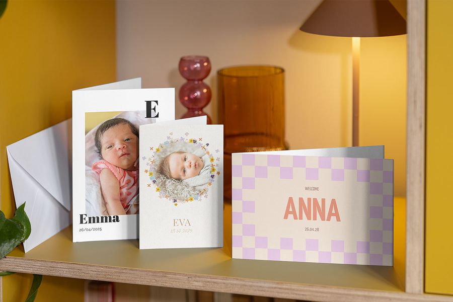 Three different designs of newborn baby cards displayed on a shelf, showing a variety of personalised cards from Photobox.