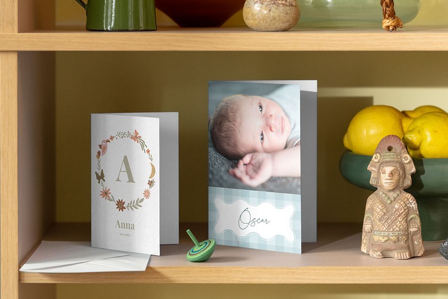 Two more newborn cards on a shelf alongside household family objects, providing inspiration on what to write in a card for a newborn from Photobox.