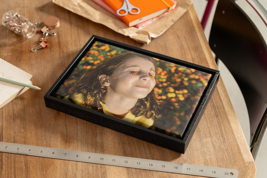 Photobox personalised canvas wall art on a table featuring a spring photo of a girl with flowers on her face, inspiring ways to print spring photography and best spring images.