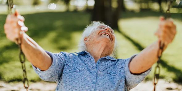 A smiling older man on a swing outside on a sunny spring day, inspiring Photobox spring photography ideas and the joy of capturing the spring season.