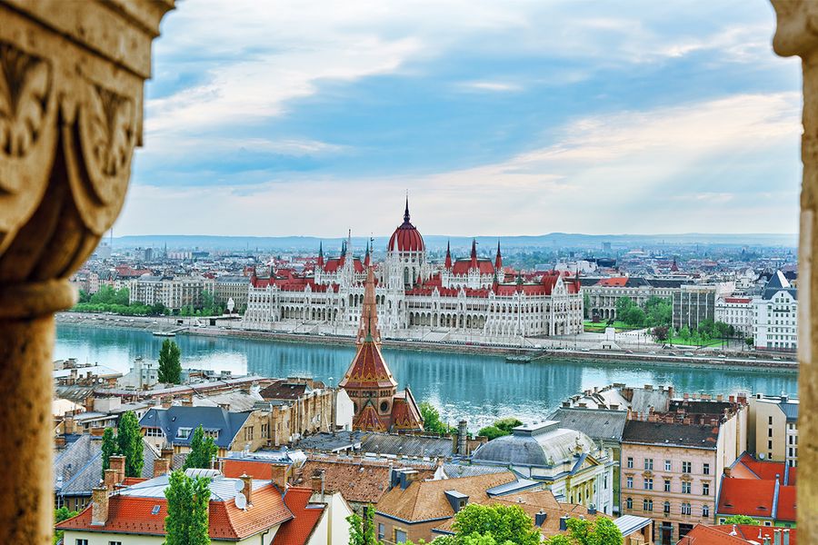 A scenic shot of the Danube river and the grand Parliament building, highlighting the architectural romance of Budapest.