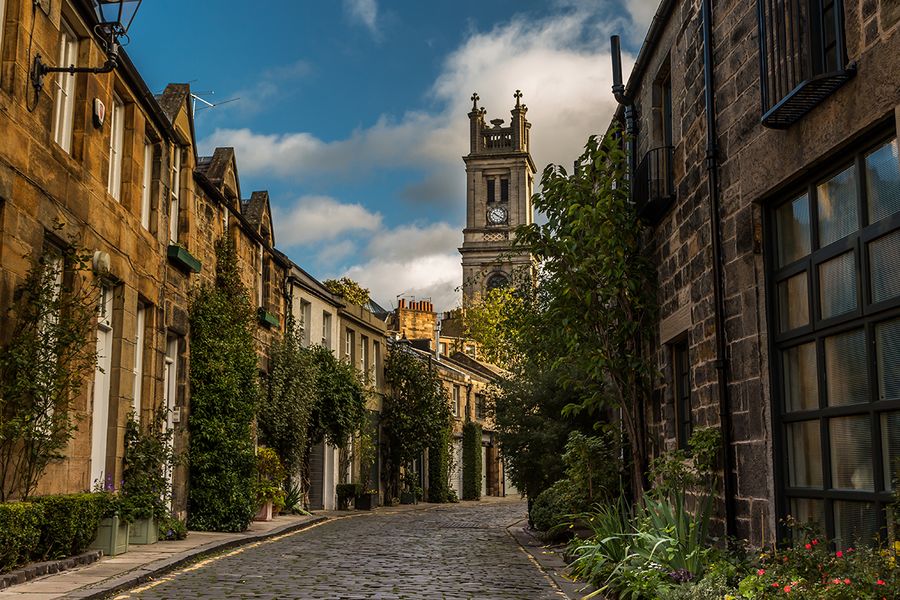 A picturesque cobbled street in Edinburgh, Scotland, showcasing the city’s historic beauty for a romantic tour.