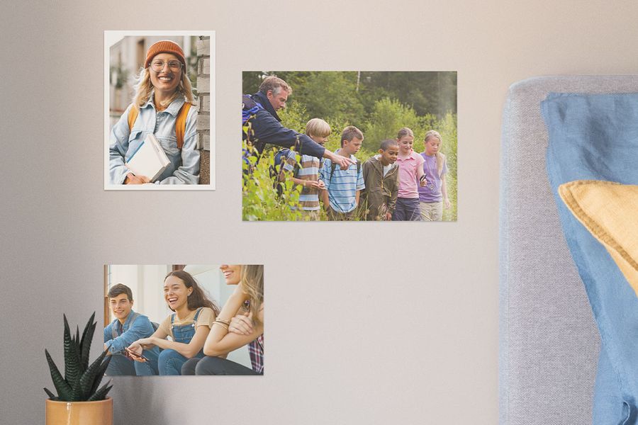 Photobox photo prints on a wall showing school memories, including a class photo, a smiling young woman and a group of teenagers, inspiring graduation gift ideas and graduation photo prints.