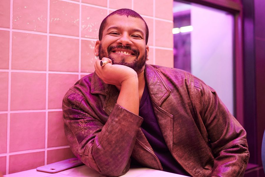 A happy man smiling alone while looking for what to write on a Valentine's Day Instagram post for singles, highlighting Valentine's day ideas for self-love with Photobox.