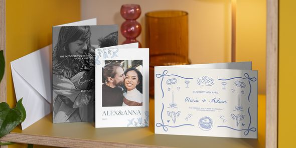 Three Photobox personalised wedding invitations displayed on a shelf, showing different wedding invitation wording and messages to inspire what to write in a wedding card.
