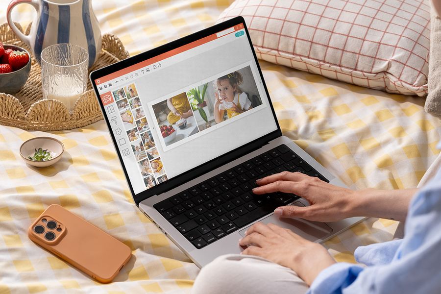 A woman uses the Photobox online photo book maker on desktop to easily create a personalised photo book.