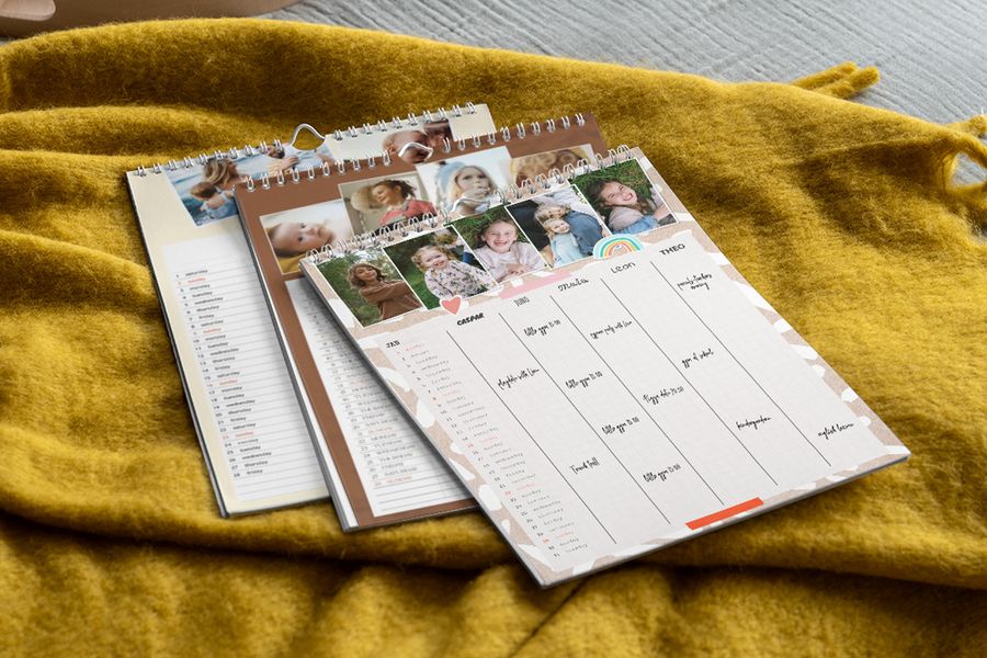 A display of various personalised Photobox family planners, showing examples of different family portraits