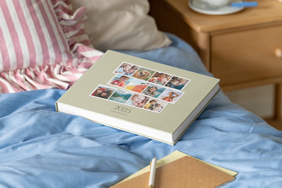 A 2025 family yearbook or year photo book resting open on a bed, ready to be read.