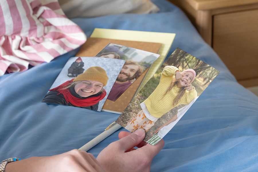 Person holding family photos to compare matt vs glossy photo prints.