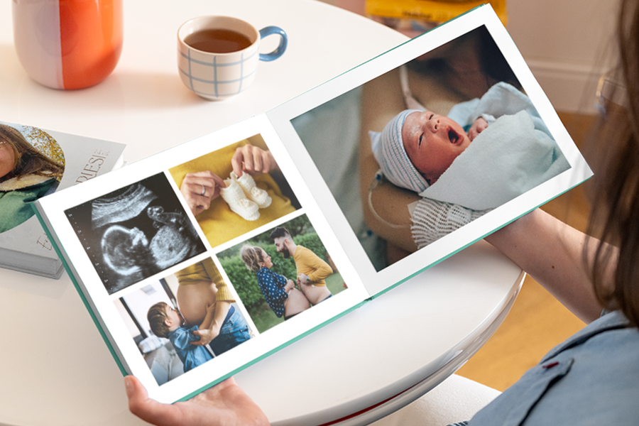 An open babys first year photo book showing a pregnant belly, ultrasound, and booties on the left page, and a newborn baby picture on the right.