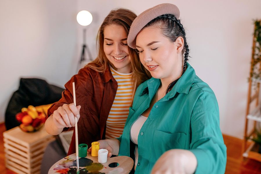 Two best friends getting creative and painting together for Galentine's Day, a wonderful way to celebrate Valentine's Day with friends and turn art into Photobox gifts.
