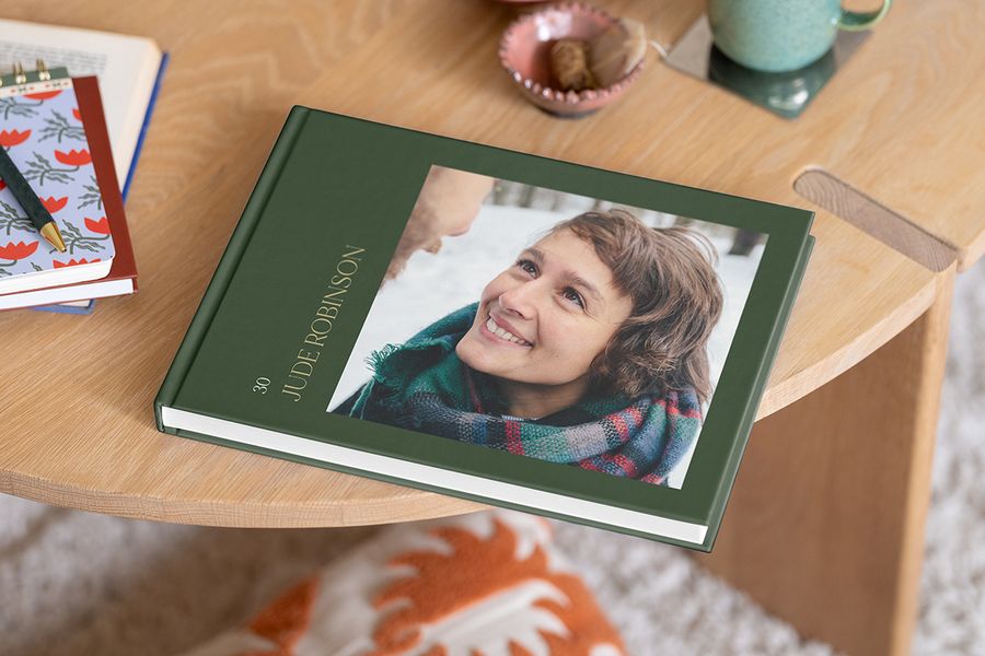 A birthday photobook from Photobox featuring a smiling woman on the cover, ideal for including celebratory birthday photo album captions and photo album quotes.