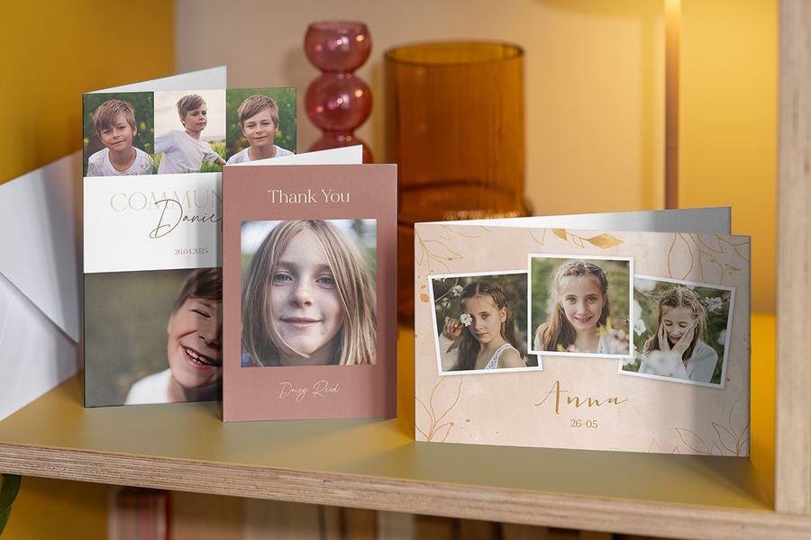 Personalised first holy communion thank you cards from Photobox for boys and girls resting on a shelf.
