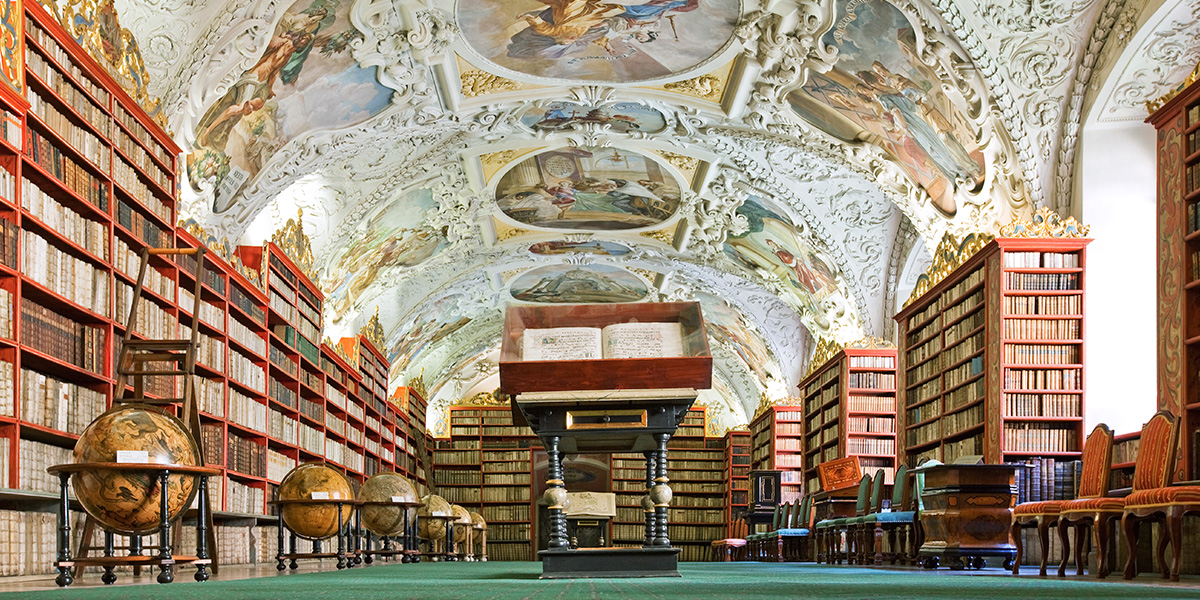 The Theological Hall of the Strahov Library in Prague, showcasing stunning stucco and globes as part of a literary travel bucket list with Photobox.