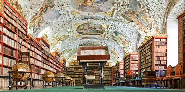 The Theological Hall of the Strahov Library in Prague, showcasing stunning stucco and globes as part of a literary travel bucket list with Photobox.