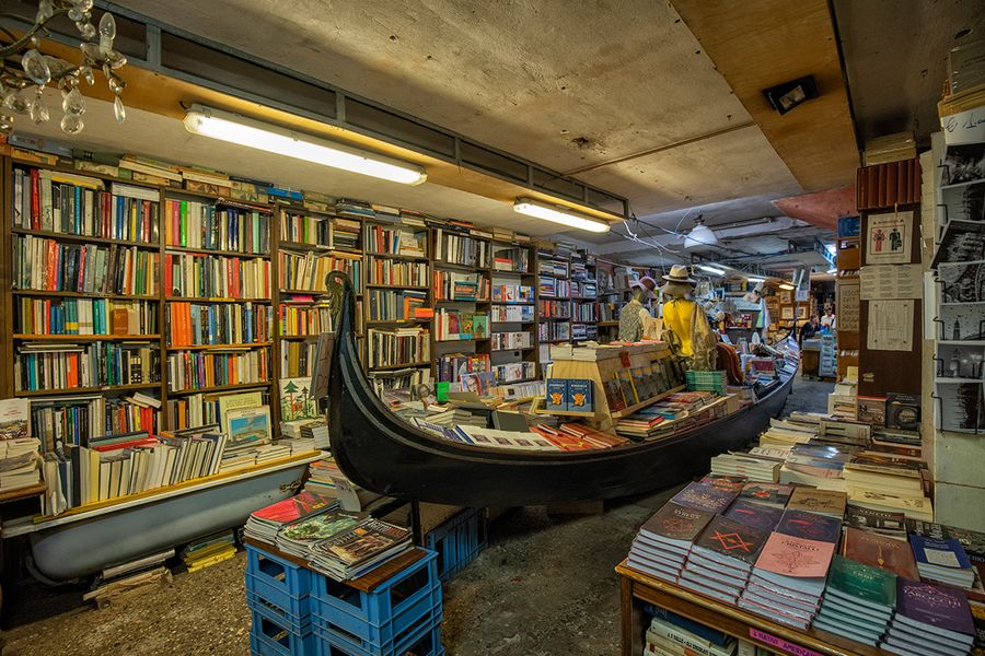 Libreria Acqua Alta in Venice, Italy, featuring books stored in a gondola and bathtubs to protect them from high tides, a quirky destination for literary travel with Photobox.