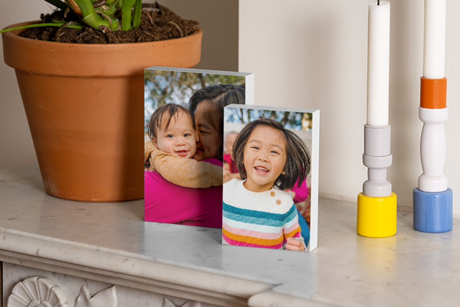 Personalised photo blocks on a fireplace mantel next to candles and a plant, showcasing home decor photo gifts for Easter and personalised gift ideas from Photobox.