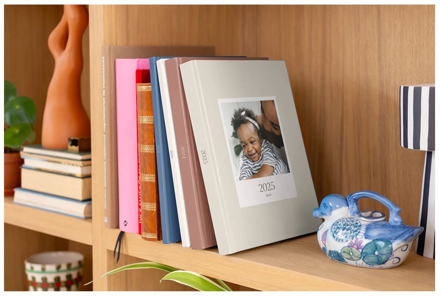 A shelf of closed hardback premium layflat yearbook photo books from Photobox, showcasing professional photo book printing and quality materials.