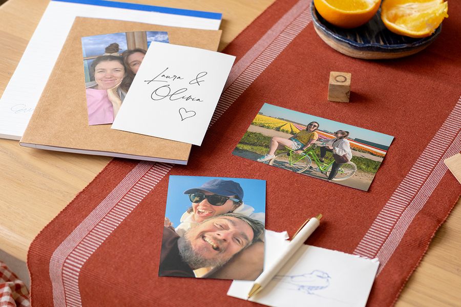 A selection of personalised photo prints and cards on a table, illustrating the love letter storytelling era and 2026 wedding trends with Photobox.