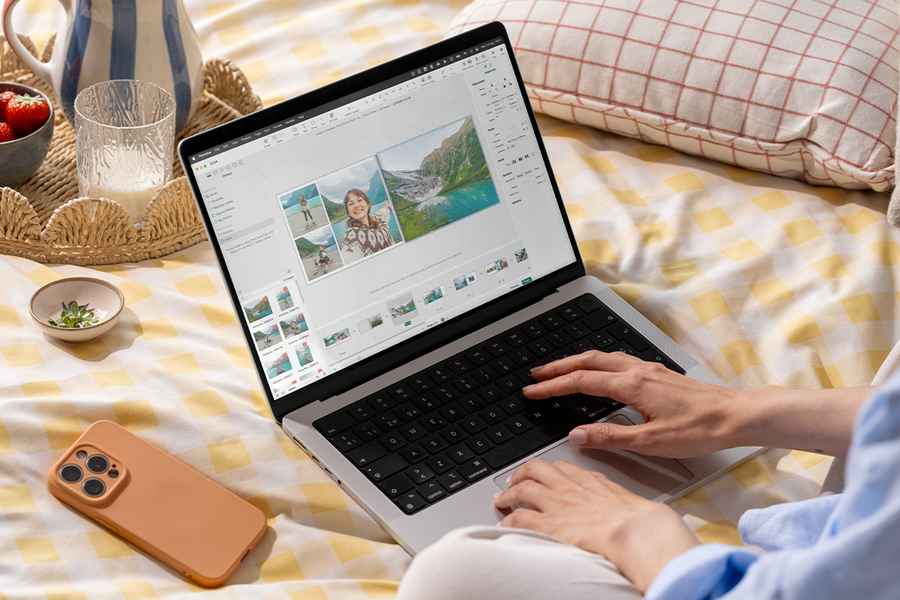 Someone using the Photobox photo book editor on a laptop while in bed, inspiring an easy photo book creator and quick and easy photo books.