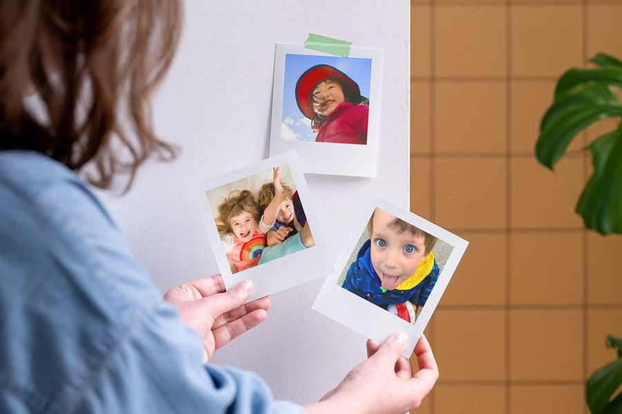 A woman holding personalised Photobox photo prints, inspiring children’s party bags and children’s party bag fillers.