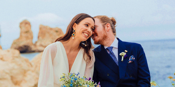 A smiling bride and groom on the beach on their wedding day, inspiring Photobox wedding games and fun wedding games for guests.