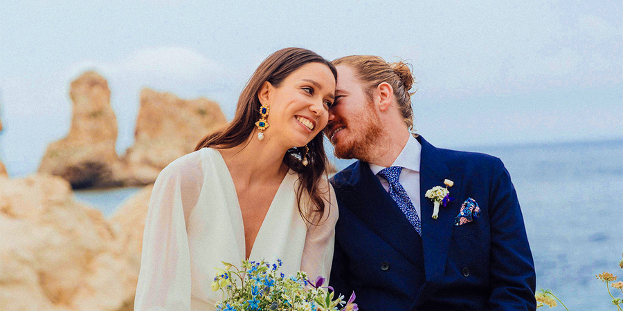 A smiling bride and groom on the beach on their wedding day, inspiring Photobox wedding games and fun wedding games for guests.