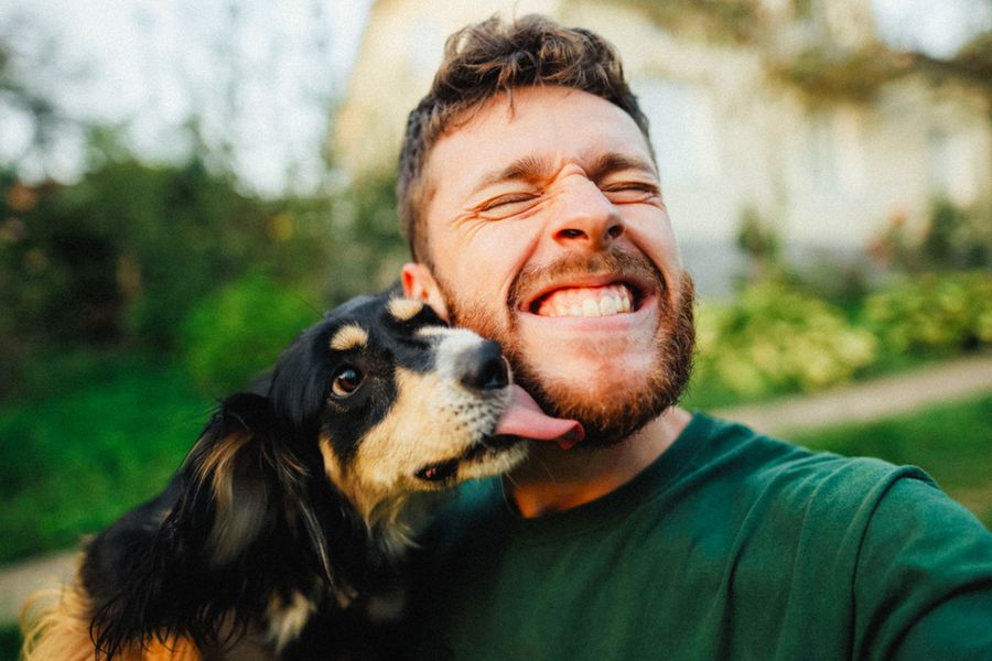 A man smiles with his dog, inspiring a Father’s Day card from the dog and funny Father’s Day messages for dog dads.