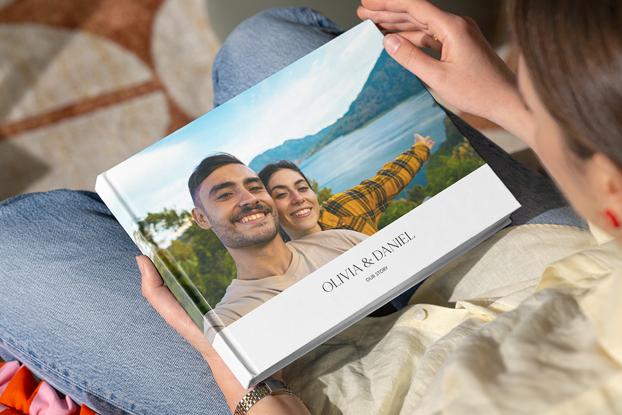 A personalised Photobox photo book with a happy couple in a scenic location on the cover, illustrating a photo book surprise as a romantic proposal idea.
